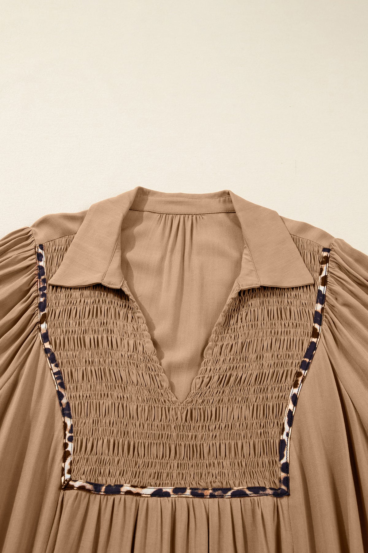 Vestido largo con cuello en V, cuello con trébol de cuatro hojas, detalle fruncido y ribete de leopardo en contraste, mangas tres cuartos.